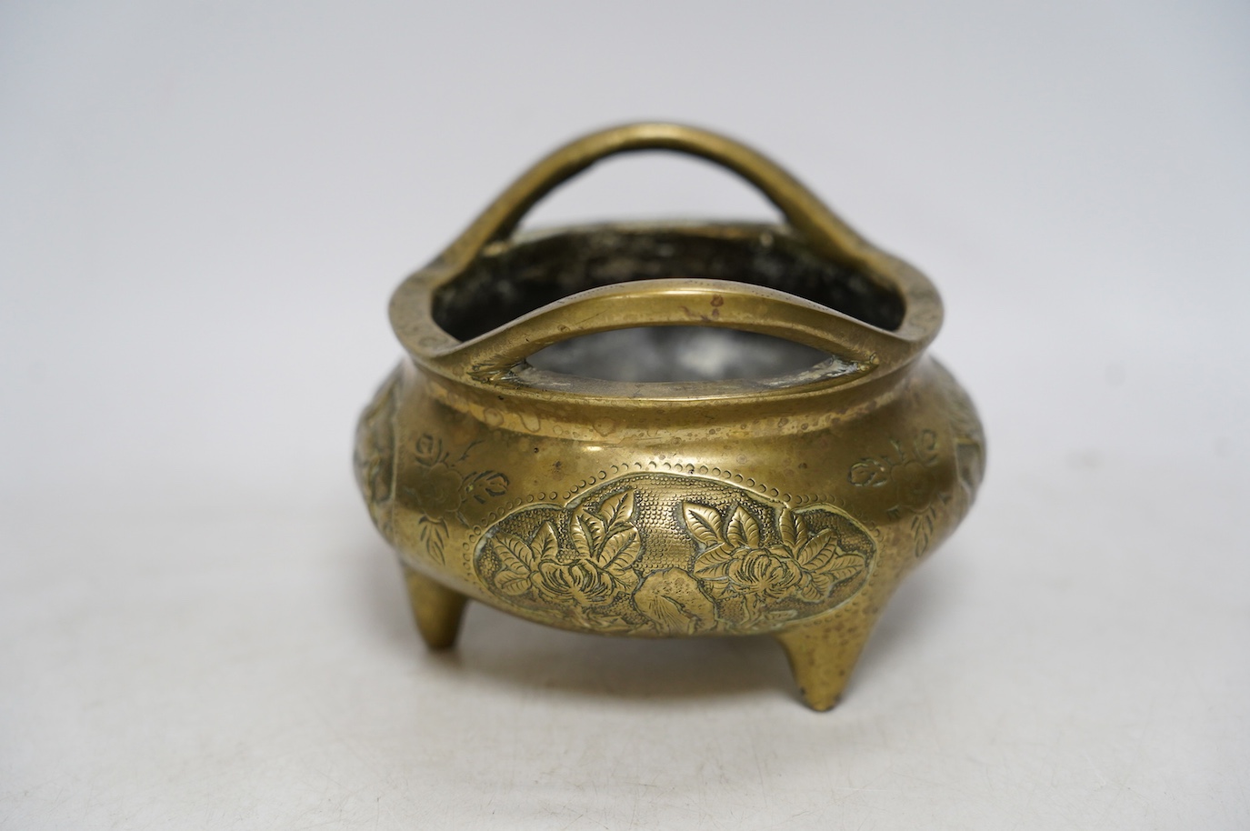 A Chinese bronze tripod censer, Xuande mark, 19th century, 13cm wide. Condition - plug repair to body